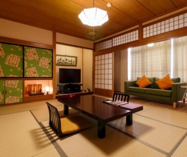 Traditional tatami room with low table, zabuton cushions, shoji screens and sofa at Oyado Koto No Yume, Gifu