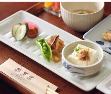 Small Japanese dishes with tofu, edamame, pickles and grilled fish on a ryokan table at Oyado Matsubaya, Gunma