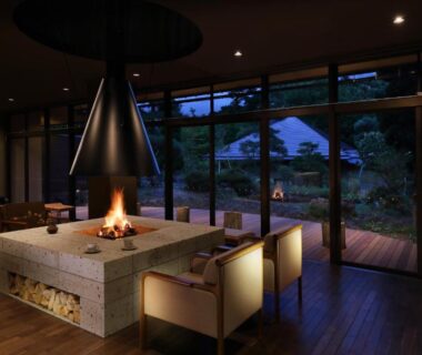Central open fireplace with seating and floor-to-ceiling windows in a lounge at Oyado Morinone, Yamagata