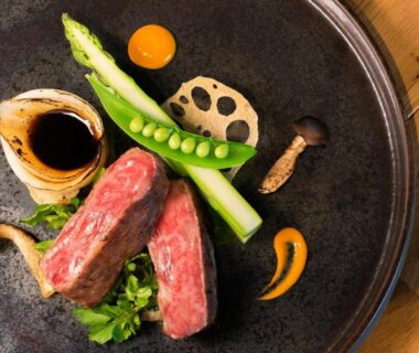 Seared beef slices with asparagus, lotus root and mushrooms on ceramic plate at Oyado Morinone Yamagata