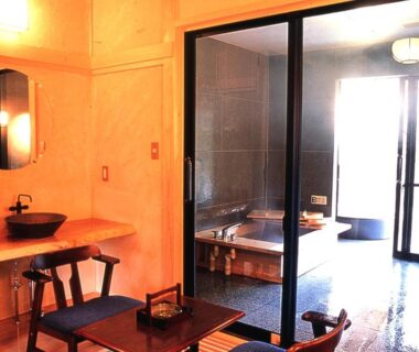 Sliding glass doors, wooden soaking tub, washbasin and low table in Oyado Sansui Nagano room