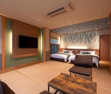Tatami room with two beds, low table and TV at Oyado Sansui in Nagano, Chūbu, Japan
