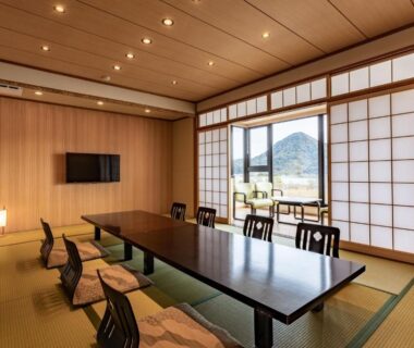 Spacious tatami room with low dining table, shoji screens and mountain view at Oyado Seri in Hyōgo