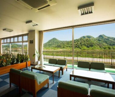 Spacious lounge with sofas and low tables overlooking green mountains at Oyado Seri in Hyōgo