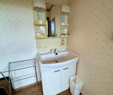Compact sink and mirror with shelving in ryokan bathroom at Oyado Tamayura, Oita, Kyushu, Japan