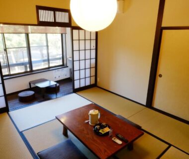 Tatami room with low table, cushions and shoji screens at Oyado Tsukiusagi in Hiroshima