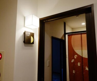 Corridor doorway with noren curtain and wall lamp at Oyado Tsukiusagi, Chūgoku, Hiroshima, Japan