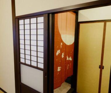 Tatami corridor with shoji doors and decorative noren at Oyado Tsukiusagi, Hiroshima, Chūgoku, Japan