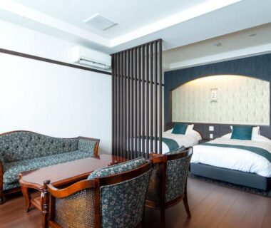 Modern ryokan guest room with twin beds, wooden flooring, seating area and decorative partition at Oyado Yukizumi in Gunma