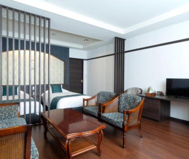 Room interior with twin beds, seating area and TV at Oyado Yukizumi in Gunma, Kantō