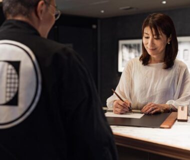 Guest signing registration at reception desk with staff in branded jacket at PROSTYLE Ryokan Yokohama Bashamichi Kanagawa