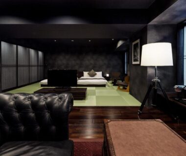 Spacious tatami room with low seating, leather sofa, shoji screens and accent lamp at PROSTYLE Ryokan Yokohama in Kanagawa