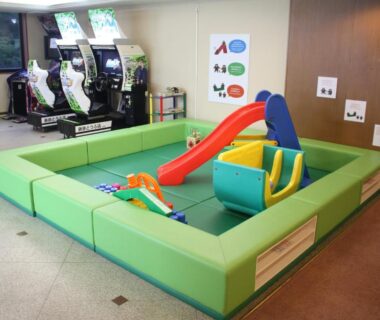 Indoor padded play corner with small slide, foam seating and arcade machines at Park Hotel Miyabitei, Hokkaidō