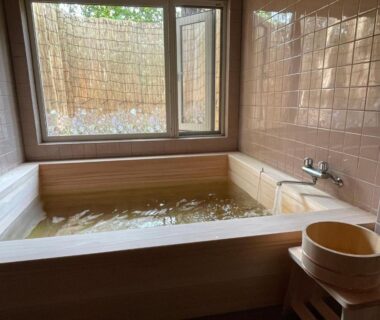 Wooden soaking tub with tiled walls, stool and window at Pension Balmy in Tochigi