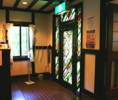 Stained glass doorway and wooden interior at Pension Marie in Yamanashi, Chubu, Japan