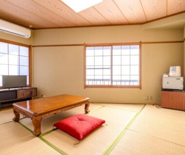 Bright tatami room with low wooden table, zabuton cushion and shoji windows at PiDDs Family 熱海 in Shizuoka