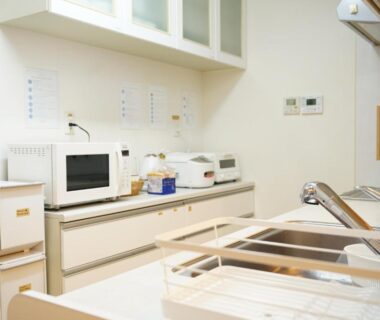 Compact kitchenette with sink, microwave and cabinets at Private stay MIYAJIMA tonbo-AND in Hiroshima, Chūgoku