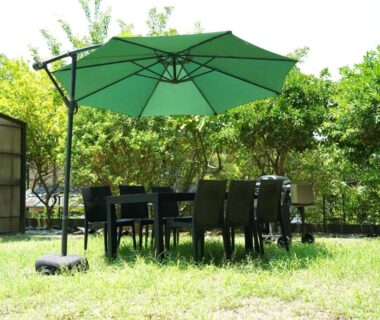 Outdoor table and umbrella on grassy lawn at Private stay MIYAJIMA tonbo-AND, Hiroshima, Japan