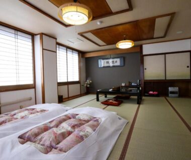 Traditional tatami room with futon bedding, low table, and shoji screens at Rakki OnsenRyokan in Nagano