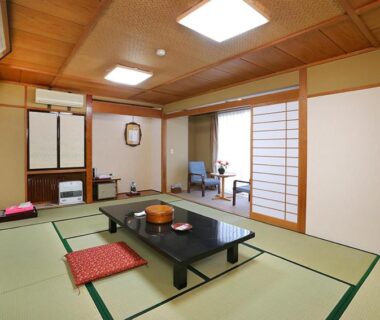 Traditional tatami room with low table, zabuton cushions and shoji screens at Rakki OnsenRyokan in Nagano Chūbu