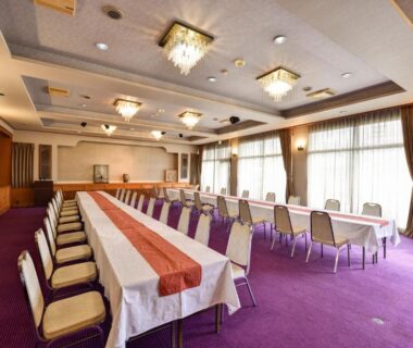 Carpeted banquet room with long tables and chandeliers at Rakusuien in Yamanashi, Chūbu