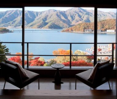 Two chairs and table by window overlooking lake and mountains at Rakuyu, Yamanashi, Chūbu, Japan