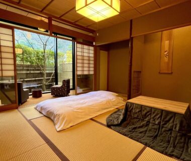 Traditional tatami room with futon, shoji screens, low table and garden view at Rangetsu in Kyoto