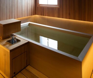 Wood-paneled bathing room with wooden soaking tub and faucet at Rangetsu Kyoto
