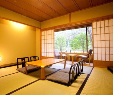 Tatami room with low table, floor chairs, shoji screens and garden view at Ranzan Kyoto