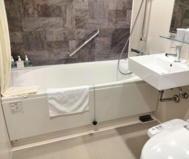 Compact modern bathroom with bathtub, wall-mounted sink and bidet-style toilet at Resorpia Beppu in Ōita