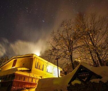 Snow-covered grounds and illuminated building at Resort Project Myoko Kogen in Niigata under stars
