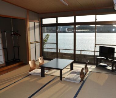 Tatami room with low table and river-view windows at Riverside Hotel Karatsu Castle, Saga, Kyūshū, Japan