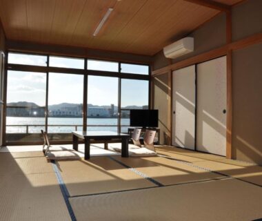 Tatami room with low table and river view at Riverside Hotel Karatsu Castle, Saga, Kyushu