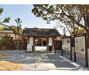 Tiled entrance gate with wooden fence and information boards at Riverside Hotel Karatsu Castle in Saga