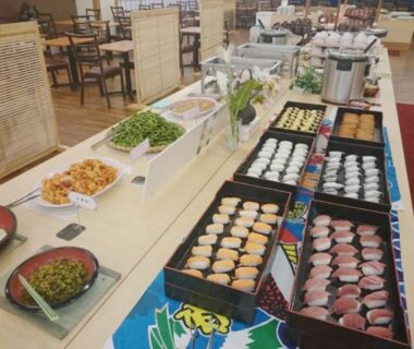 Assorted sushi, side dishes and buffet stations in ryokan dining area at Riverside Uedakan Nagano