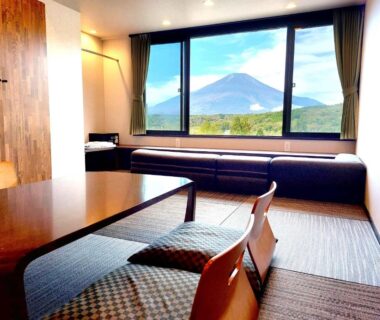 Tatami seating area with low table and cushions, large window overlooking mountain at Rokumeikan Hills, Yamanashi