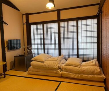 Tatami floor with folded futons and shoji screens at Roman Kan ryokan, Kyoto Kansai
