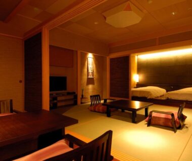 Warm tatami room with futon beds, low table, shoji screens and ambient lighting at Rurikoh in Ishikawa