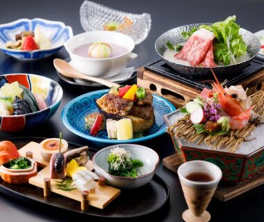 Assorted traditional Japanese dishes on lacquer trays and ceramic bowls, sashimi and grilled dishes arranged for a ryokan meal