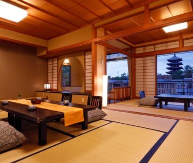 Traditional tatami room with low table, shoji screens and pagoda visible through window at Ryokan Asukasou, Nara