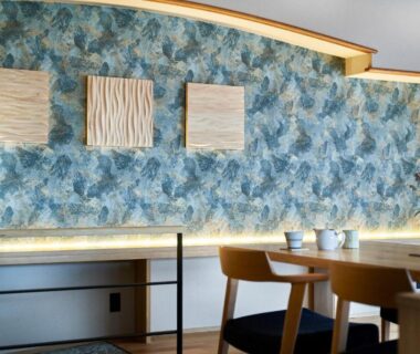 Wooden dining table with chairs, patterned blue wall panels and tea set at Ryokan Asukasou near Nara park