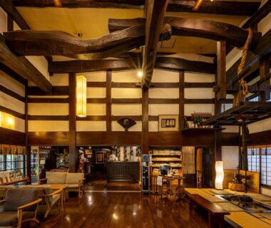 Spacious wooden lobby with exposed beams, seating and shoji screens at Ryokan Asunaro, Gifu, Chūbu, Japan