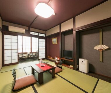 Traditional tatami room with low table, zabuton cushions and shoji screens at Ryokan Asunaro in Gifu
