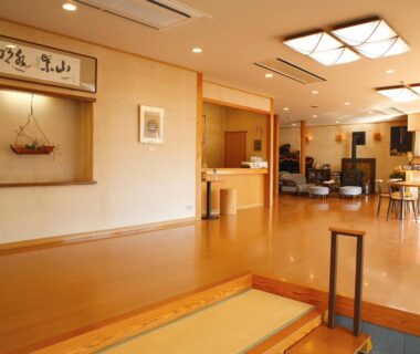 Spacious wooden-floored lobby with reception desk and seating at Ryokan Chinsen-Rou in Kyoto, Kansai