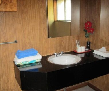 Sink counter with folded towels and mirror at Ryokan Fuji in Tokyo