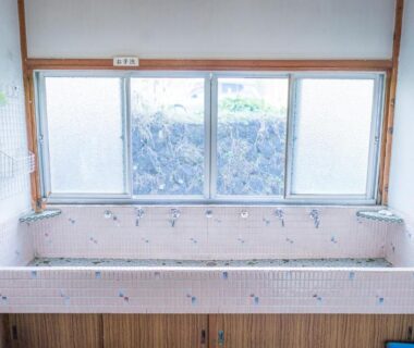 Tiled bath with frosted windows and wooden base at Ryokan Fuji Heights, Yamanashi