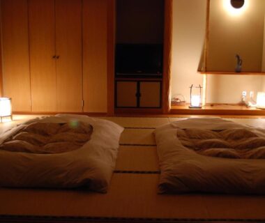 Low-lit tatami room with two futon beds at Ryokan Fukuzen in Gunma, Kantō