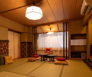 Traditional tatami room with low table, floor cushions, shoji screens and warm lighting at Ryokan Gizan in Gifu