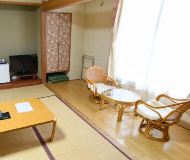 Tatami mats, low table and wicker seating at Ryokan HANAEMI in Hokkaidō