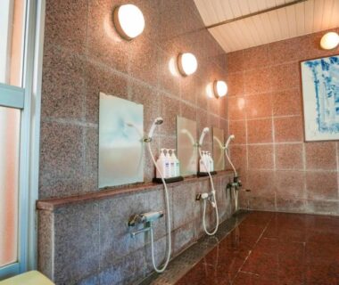 Tiled communal washing area with stools and showerheads at Ryokan Hirayama, Kumamoto, Kyūshū, Japan